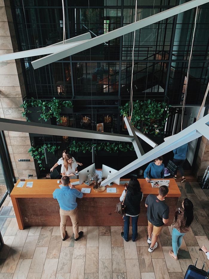 Aerial view of a modern hotel reception with people interacting at the desk in Sosnivka, Ukraine.