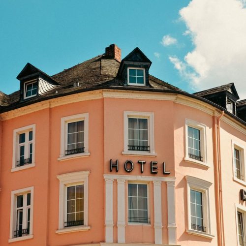 Charming facade of a boutique hotel in Bernkastel-Kues under a clear summer sky.